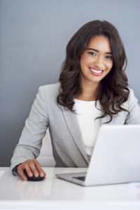 Cropped portrait of a happy, young businesswoman working on her laptop - ergonomics